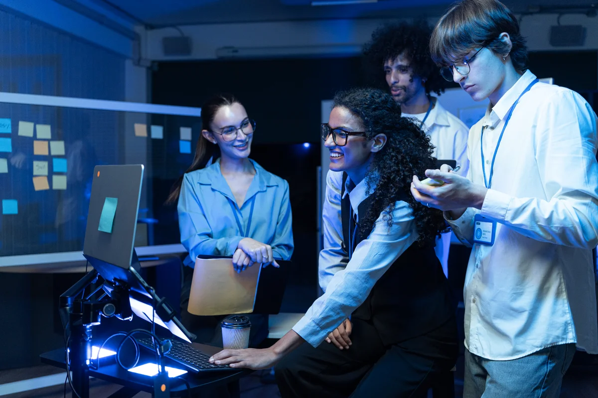 Consultants reviewing data on large screens in a technology control room